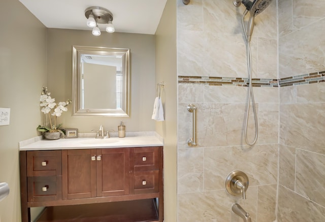 bathroom with a tile shower and vanity