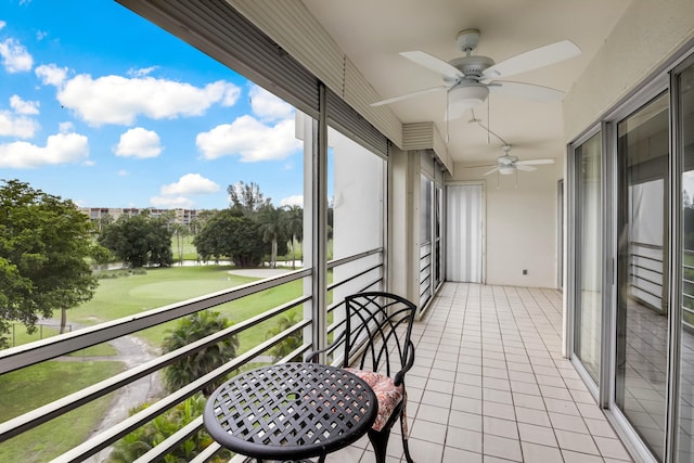 balcony with view of golf course and a ceiling fan