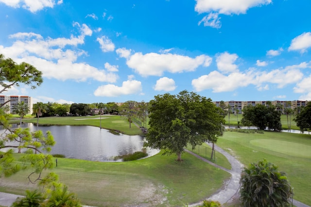 view of property's community featuring view of golf course, a water view, and a yard