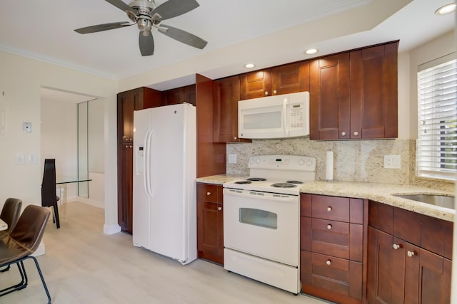 kitchen with backsplash, light wood finished floors, a ceiling fan, and white appliances