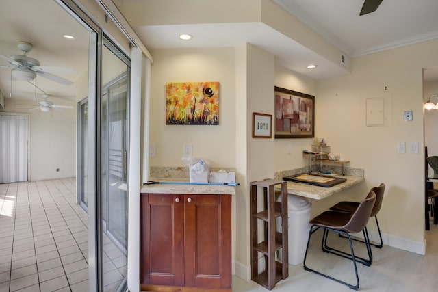 tiled dining space featuring ornamental molding and ceiling fan