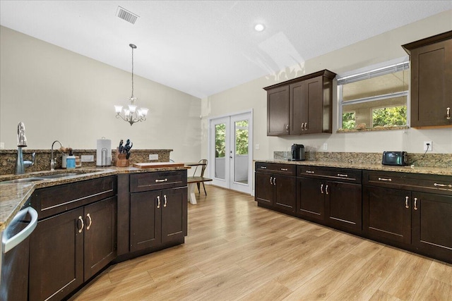 kitchen with dark brown cabinetry, light wood-type flooring, and vaulted ceiling