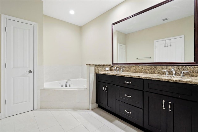 bathroom featuring vanity, tile patterned flooring, and a relaxing tiled tub