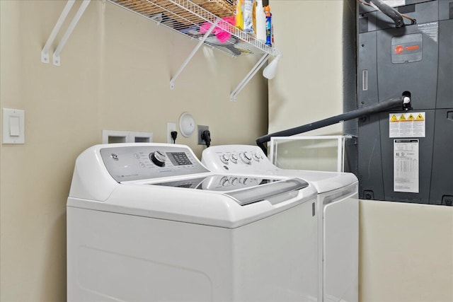 laundry area featuring heating unit and separate washer and dryer