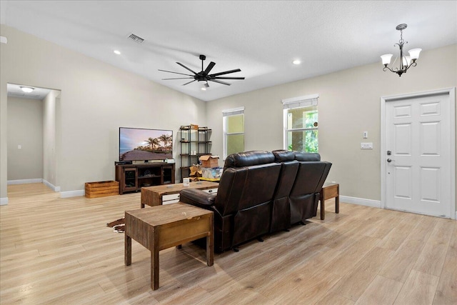 living room with light wood-type flooring, ceiling fan with notable chandelier, and lofted ceiling