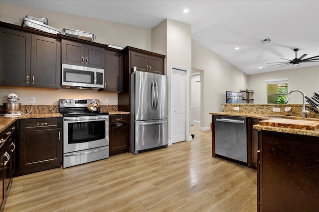 kitchen with vaulted ceiling, light hardwood / wood-style floors, stainless steel appliances, and sink