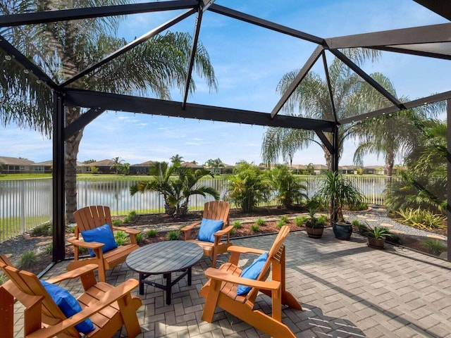 view of patio with a lanai and a water view