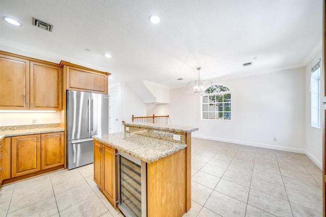 kitchen featuring stainless steel refrigerator, a center island, light stone countertops, and wine cooler