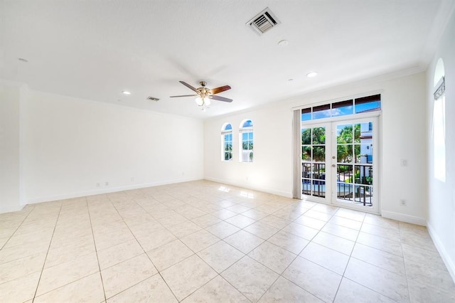 tiled spare room with crown molding, french doors, and ceiling fan