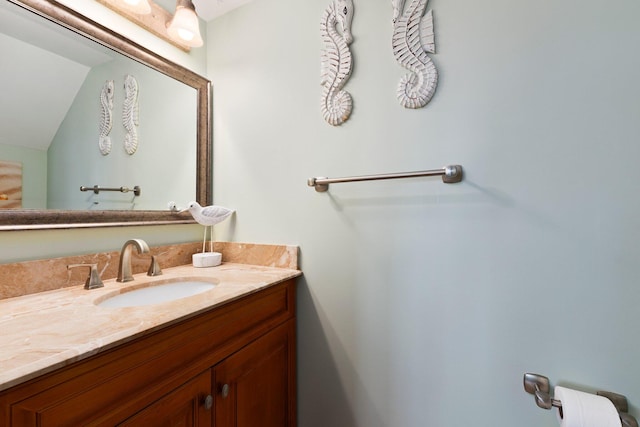 bathroom featuring lofted ceiling and vanity