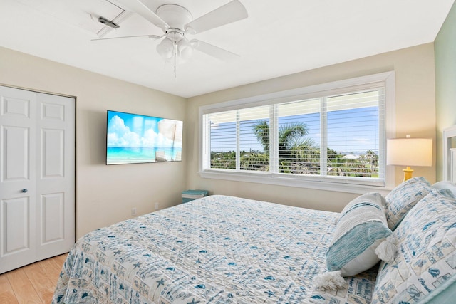 bedroom featuring a closet, multiple windows, light wood-type flooring, and ceiling fan