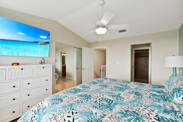 bedroom with ceiling fan, lofted ceiling, light wood-type flooring, and a closet