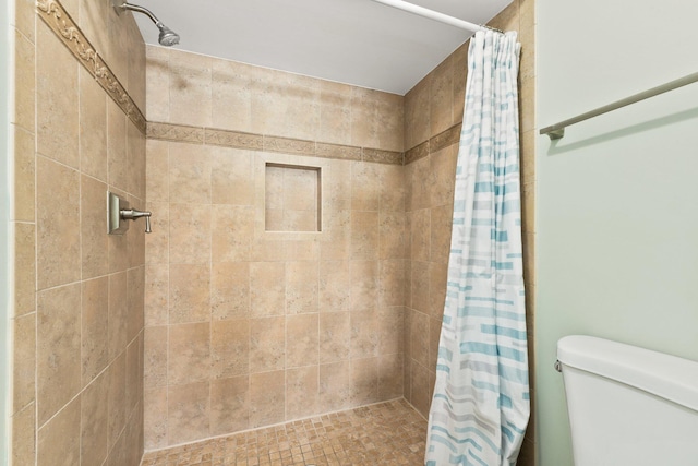 bathroom featuring toilet and curtained shower