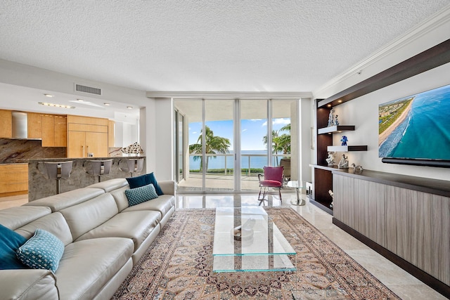 living room featuring expansive windows, a water view, a textured ceiling, and ornamental molding