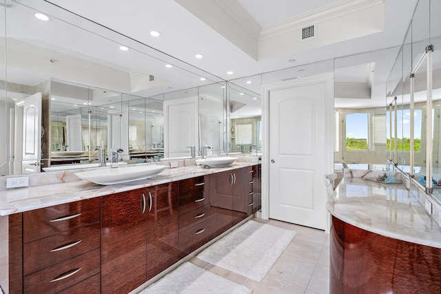 bathroom featuring tile patterned flooring, vanity, a tray ceiling, and ornamental molding