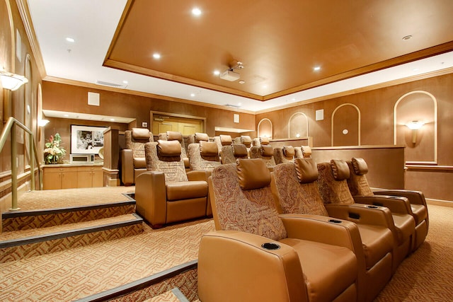 cinema room featuring carpet flooring, a raised ceiling, and ornamental molding