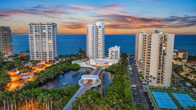 aerial view at dusk featuring a water view