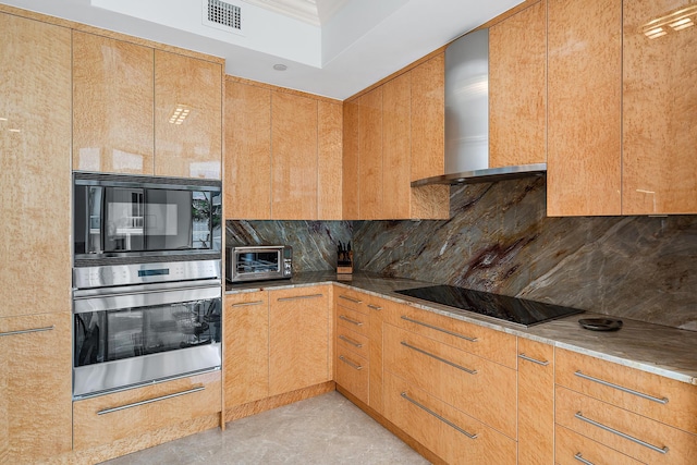 kitchen with wall chimney range hood, backsplash, and black appliances