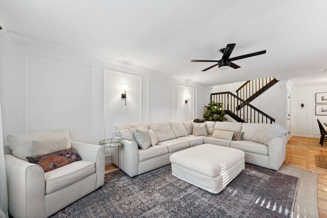 living room with ceiling fan and ornamental molding