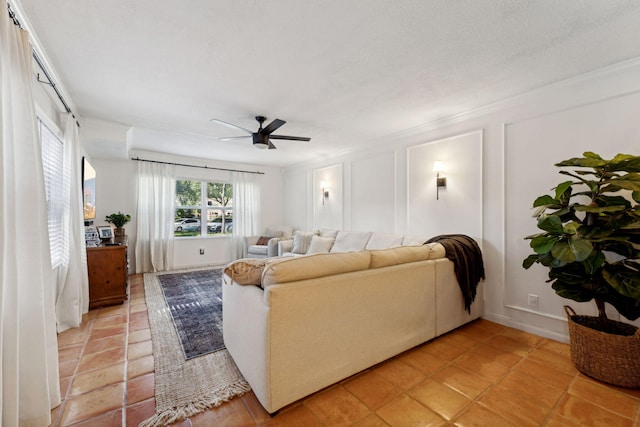 tiled living room with ceiling fan, a textured ceiling, and ornamental molding