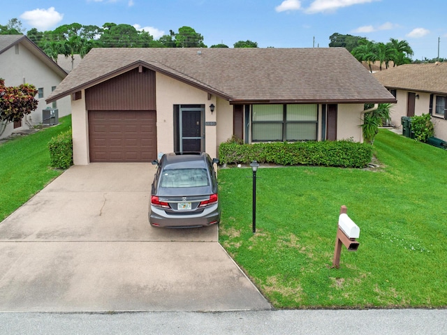 ranch-style home featuring a front yard, cooling unit, and a garage