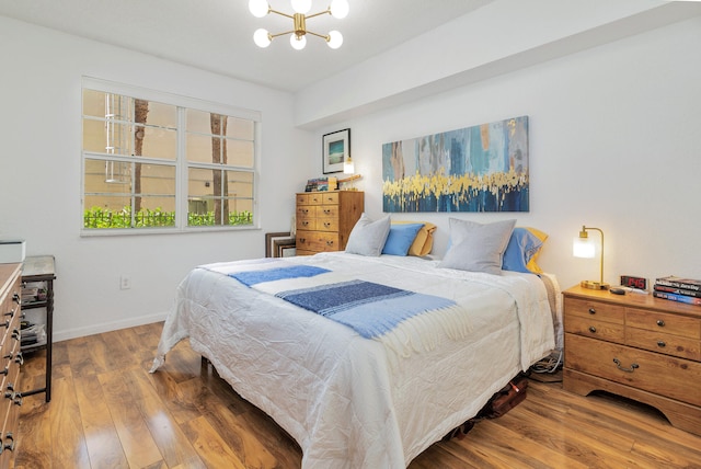 bedroom featuring an inviting chandelier and hardwood / wood-style flooring