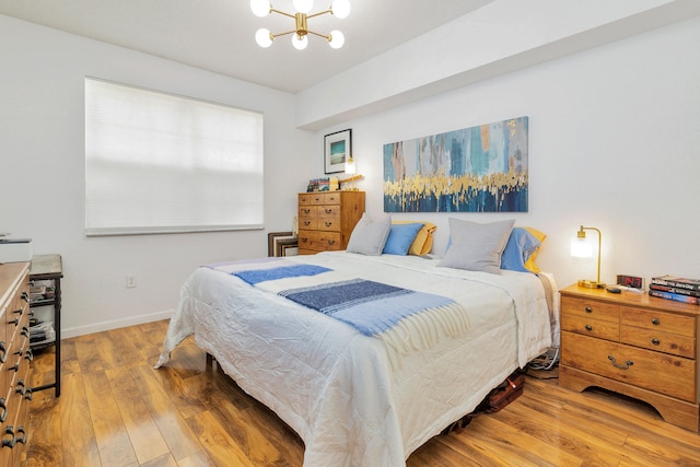 bedroom featuring an inviting chandelier and hardwood / wood-style floors