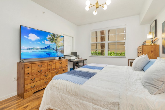 bedroom with wood-type flooring and an inviting chandelier