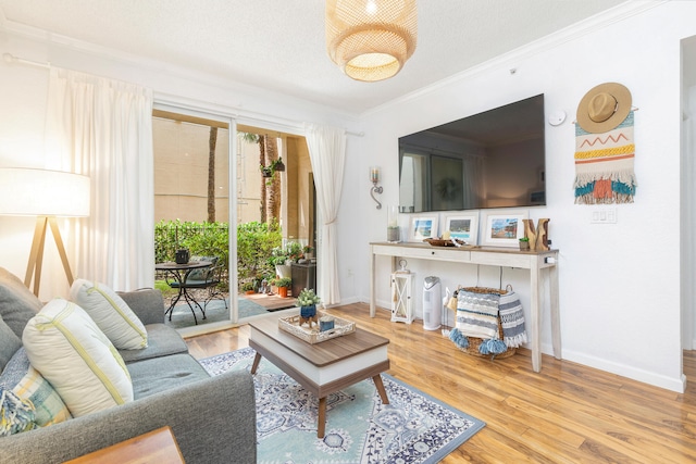 living room with wood-type flooring, a textured ceiling, and ornamental molding