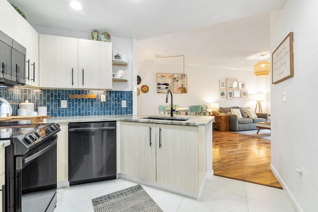 kitchen featuring kitchen peninsula, sink, black appliances, light hardwood / wood-style floors, and decorative backsplash