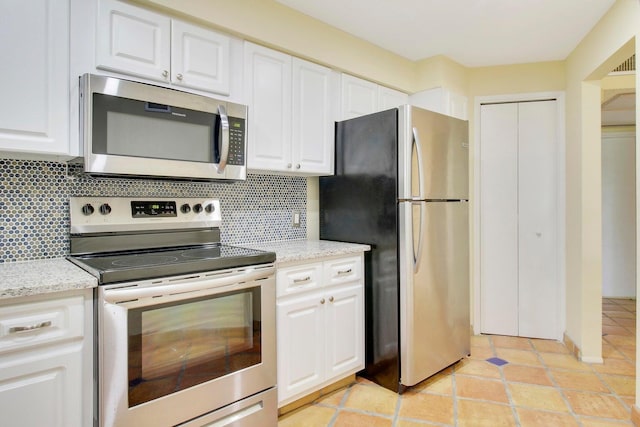 kitchen featuring decorative backsplash, stainless steel appliances, white cabinetry, and light stone counters