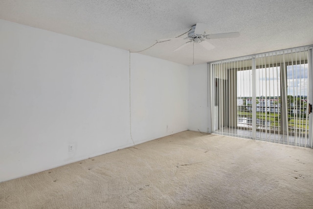 spare room with ceiling fan, carpet floors, and a textured ceiling