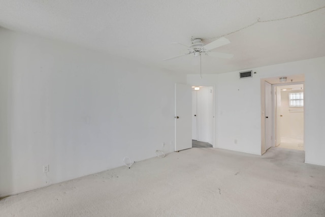 spare room with ceiling fan and light colored carpet