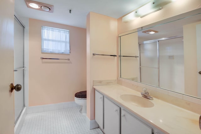 bathroom with tile patterned flooring, vanity, toilet, and a shower with door