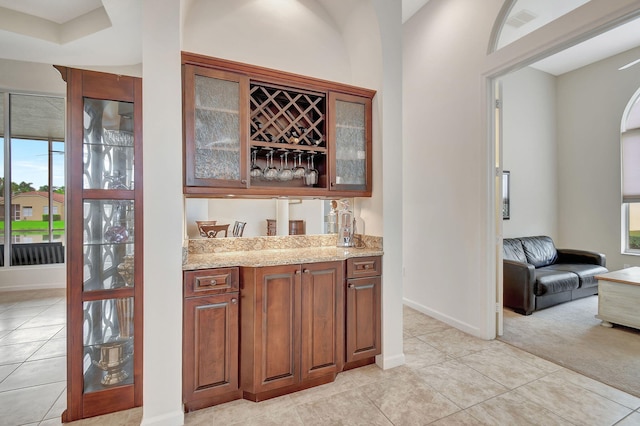 bar featuring light stone counters and light colored carpet