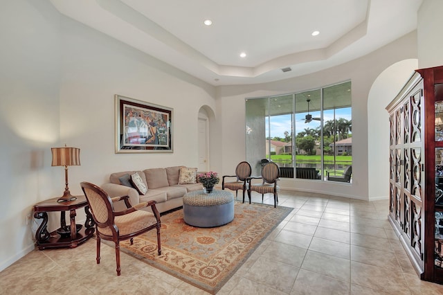 9772 Via Grandezza W, Wellington, FL 33411 - living area featuring a tray ceiling, arched walkways, recessed lighting, and light tile patterned floors