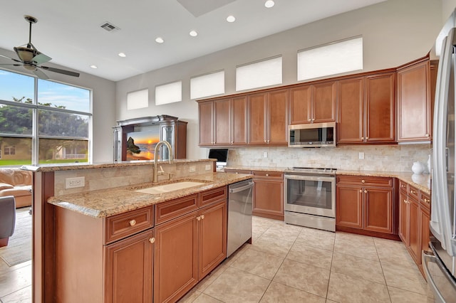 kitchen with sink, decorative backsplash, appliances with stainless steel finishes, light tile patterned floors, and ceiling fan