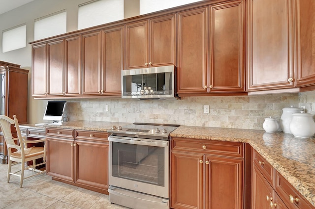 9772 Via Grandezza W, Wellington, FL 33411 - kitchen with light stone countertops, brown cabinetry, appliances with stainless steel finishes, and tasteful backsplash