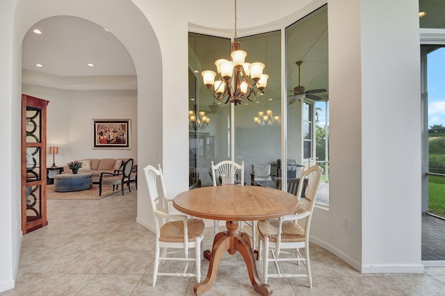 9772 Via Grandezza W, Wellington, FL 33411 - tiled dining space featuring arched walkways, an inviting chandelier, and a wealth of natural light