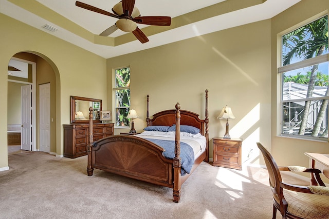 carpeted bedroom featuring a towering ceiling, ceiling fan, and multiple windows