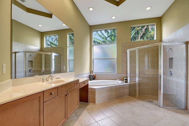 bathroom featuring plus walk in shower, vanity, tile patterned flooring, and a healthy amount of sunlight