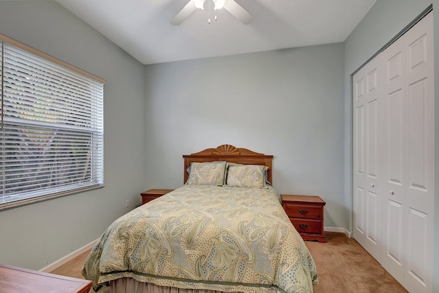 bedroom featuring ceiling fan, light carpet, and a closet