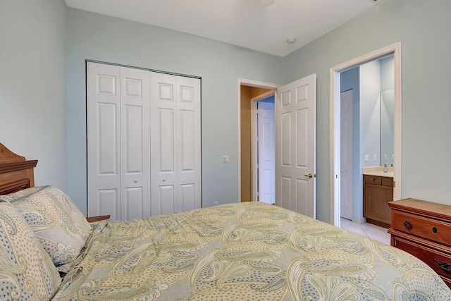 bedroom with light tile patterned floors, a closet, and ensuite bathroom