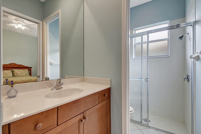 bathroom featuring ceiling fan, a shower with door, vanity, and toilet