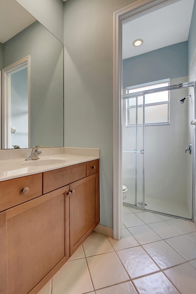 bathroom with tile patterned floors, walk in shower, vanity, and toilet