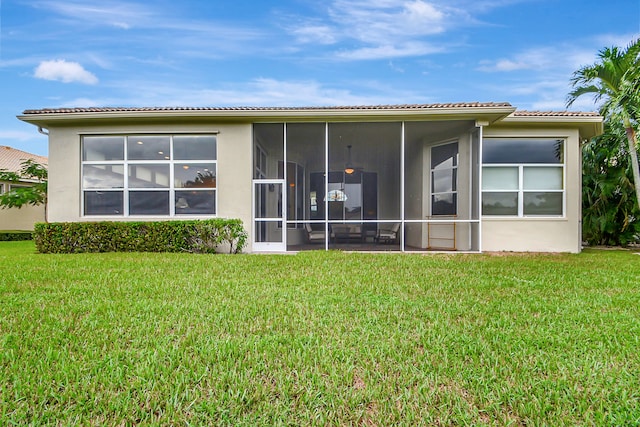 rear view of house with a sunroom and a yard