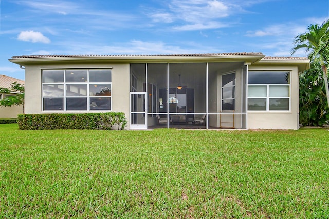 9772 Via Grandezza W, Wellington, FL 33411 - back of house with a lawn, a tile roof, a sunroom, and stucco siding