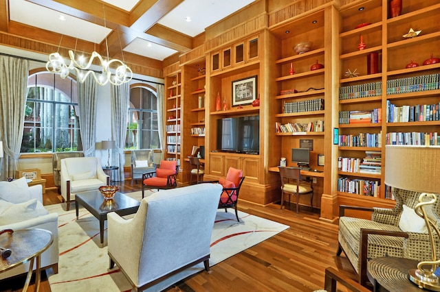 sitting room featuring beamed ceiling, built in features, wood-type flooring, wooden walls, and coffered ceiling