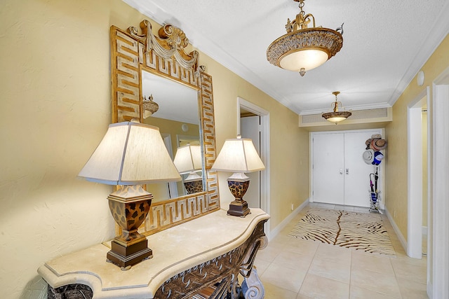 tiled entrance foyer with ornamental molding and a textured ceiling