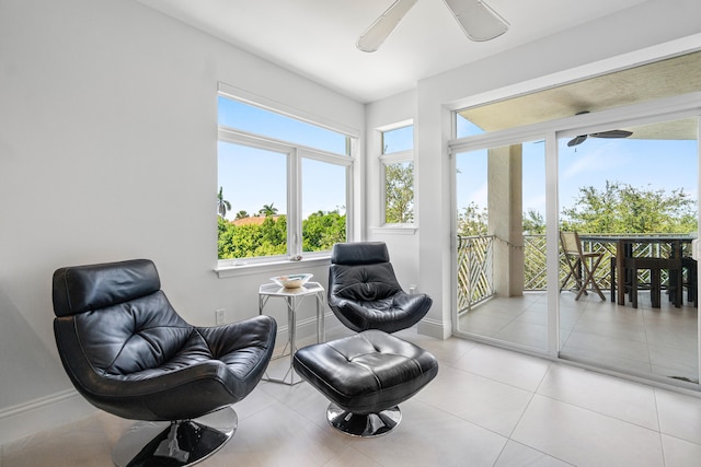 living area with ceiling fan and light tile patterned floors